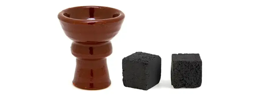 Traditional Egyptian style hookah bowl next to pieces of charcoal